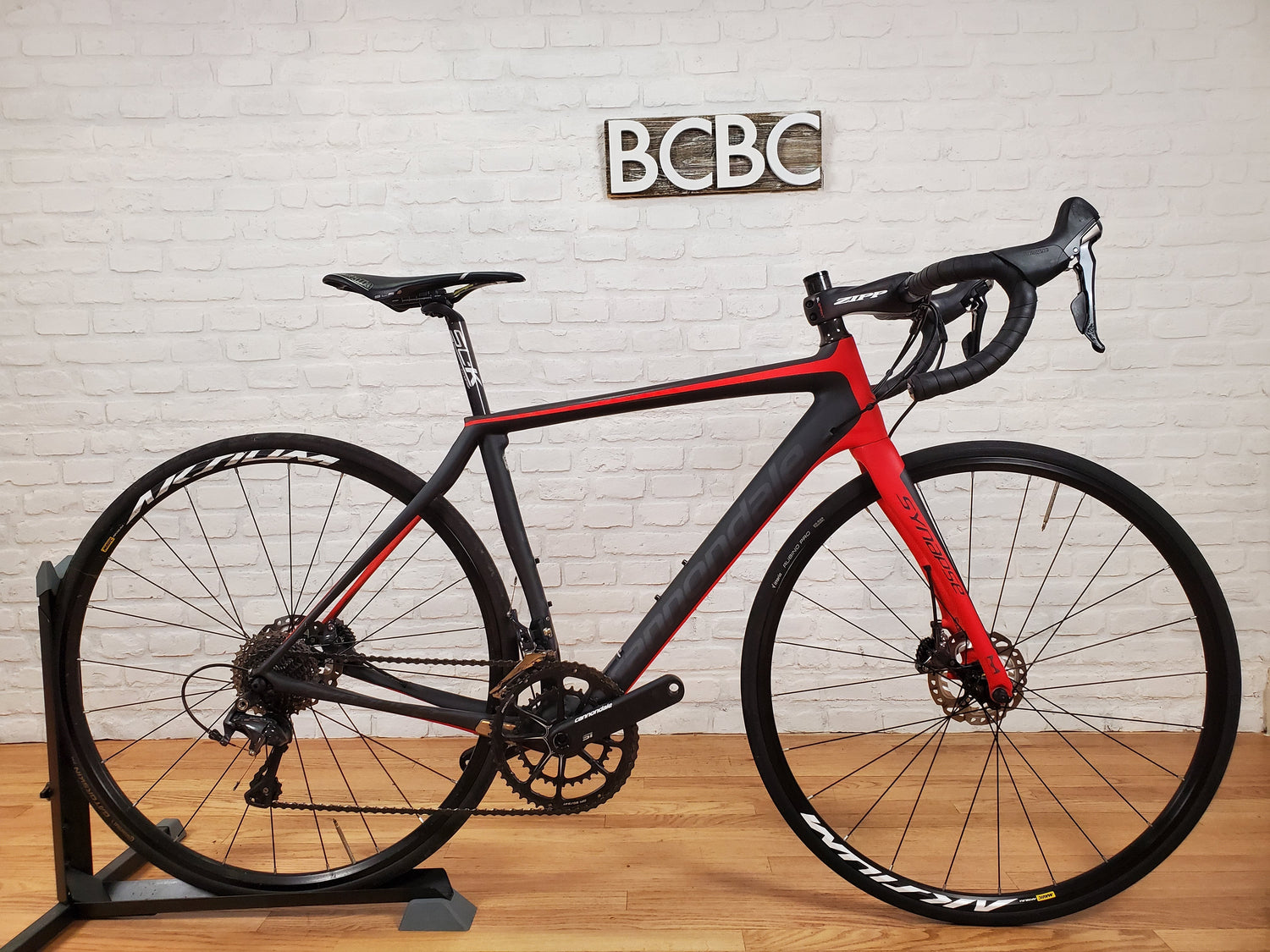 A collection of pre-owned Cannondale road bikes, including SuperSix EVO and Synapse models, displayed in a showroom setting.