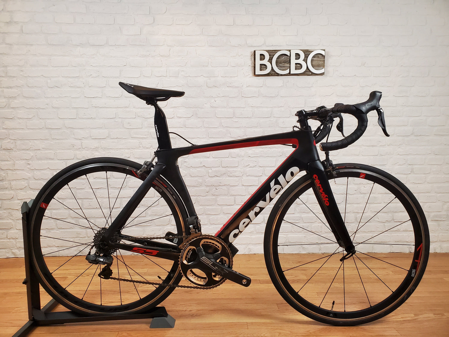 A collection of pre-owned Cervelo carbon road and gravel bikes, including R5, S5, and Aspero models, displayed in a bike shop setting.