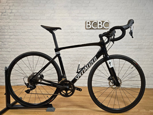 Side view of the 2022 Specialized Roubaix Sport Disc 105, featuring a Fact 10r carbon frame, endurance geometry, and Shimano 105 groupset.